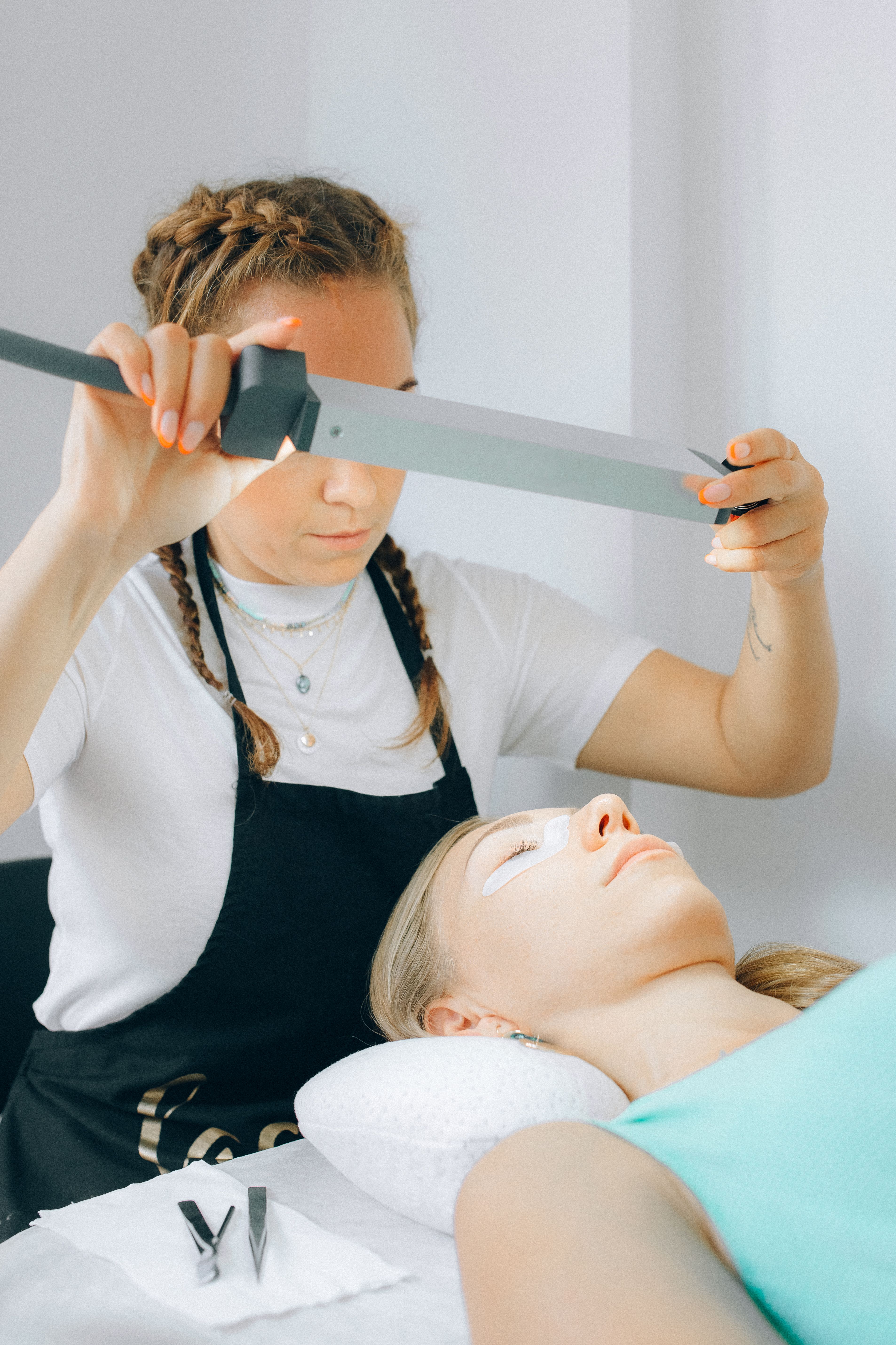 A beauty professional working with a client during an aesthetics service